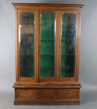 A Continental oak bookcase with moulded and carved cornice, the interior fitted shelves enclosed by 3 panelled glass doors, the base fitted 3 long drawers 77"h x 55 1/2"w x 15 1/2"d