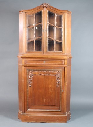 A 19th Century Continental carved walnut corner cabinet, the upper section fitted shelves enclosed by a bevelled panelled mirrored door, fitted 1 long drawer above a double cupboard 75"h x 35"w x 23"d
