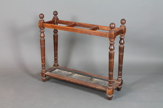 A Victorian turned beech stick stand, raised on turned and block supports complete with drip tray 32" x 36" x 12" 
