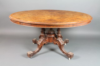 A Victorian figured walnut oval snap top Loo table, raised on 4 turned columns and splayed (complete with bolts) 