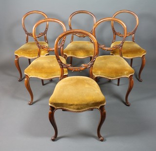 A set of 6 Victorian walnut balloon back dining chairs, the seats of serpentine outline raised on French cabriole supports 
