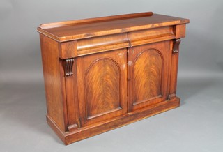 A Victorian mahogany chiffonier fitted 2 long drawers above a double cupboard enclosed by arched panelled doors, with Vitruvian scrolls to the sides, raised on a platform base 34"h x 47 1/2"w x 18"d