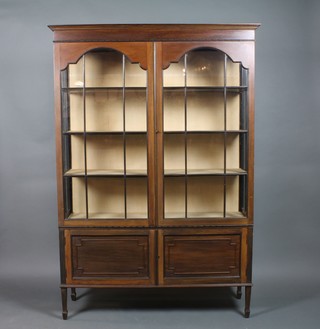 An Edwardian mahogany display cabinet with moulded cornice, the upper section fitted shelves enclosed by astragal glazed panelled doors, the base fitted a cupboard enclosed by panelled doors, raised on square tapering supports ending in spade feet 73"h x 50"w x 15"d