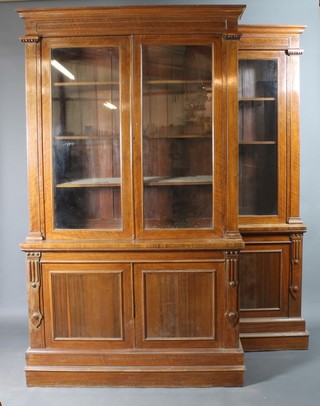 A pair of Victorian rosewood open bookcases with moulded cornices, fitted adjustable shelves, the bases fitted double cupboards enclosed by panelled doors raised on a stepped platform base 88"h x 50"w x 16"d 