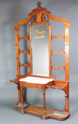 A Victorian walnut hall stand of arched shape with mirrored back, the base fitted a white marble top above 1 long drawer flanked by a pair of stick stands complete with drip trays 99"h x 56"w x 12"d 