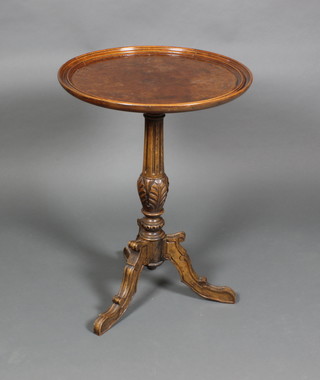 A Victorian figured walnut wine table raised on a turned fluted column and tripod base 30"h x 22"diam.