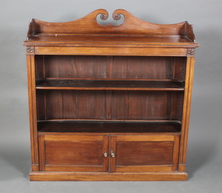 A Victorian rosewood bookcase, the raised top with three-quarter gallery and broken pediment, the interior fitted a shelf above a double cupboard enclosed by a panelled door, raised on a platform base 50 1/2"h x 48"w x 14"d