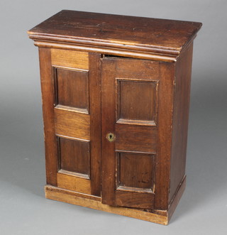 A cedar table top cigar cabinet with moulded cornice, fitted 3 shelves enclosed by a panelled door 23"h x 18"w x 10"d