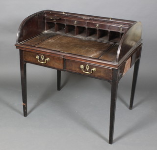 A Georgian mahogany writing table enclosed by a D shaped tambour shutter, the interior fitted pigeon holes, drawers and 2 candle slides, the base fitted 2 long drawers and 2 brushing slides