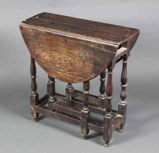 A 17th/18th Century oak oval drop flap gateleg tea table fitted a frieze drawer, raised on turned and block supports, some worm, 27"h x 27"w x 9 1/2"d when closed