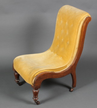 A Victorian walnut show frame nursing chair upholstered in yellow material