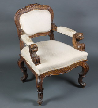 An Italian style carved walnut open arm chair with upholstered seat and back, on cabriole legs 