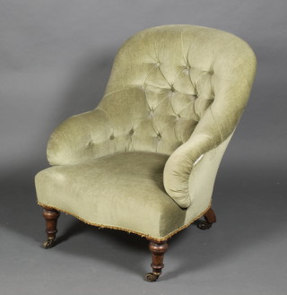 A late Victorian button back nursing chair with serpentine seat on tapered legs, brass caps and casters