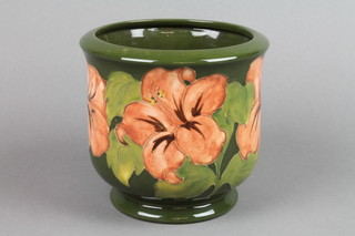 A Walter Moorcroft green ground jardiniere with hibiscus decoration, impressed marks and monogram 5"