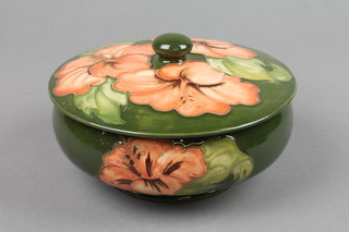 A 1940's Walter Moorcroft green ground bowl and cover with hibiscus decoration, impressed marks and printed label 5.5"