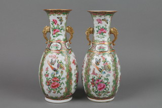 A pair of 19th Century Catonese vases with panels of exotic birds and insects among flowers with stylised dragon handles 10"