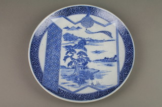 A late 19th Century Japanese blue and white transfer dish decorated with an extensive landscape in a geometric border 13" 