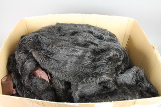A fur stole, a brown simulated fur coat and a black simulated fur coat 