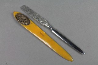 An Art Nouveau plastic and bronze mounted paper knife, the blade marked Lourdes, together with a stainless steel paper knife