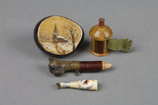 A section of painted conker decorated a church, a miniature pencil carved a dogs mask, a miniature carved bone charm in the form of a bottle 1" and a wooden miniature tape measure