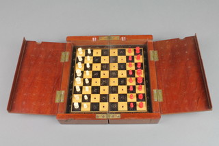A Victorian folding mahogany cased travelling chess set with red and white ivory pieces