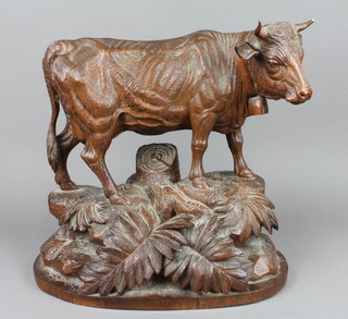 A handsome 19th Century Black Forest carved figure of a standing cow, raised on a naturalistic base with fern and tree stump decoration 11 1/2", 