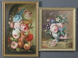 G A Humphrey, oils, still life study of an earthenware vase with spring flowers, signed 15 1/2" x 9.5" and a Delft vase containing spring flowers on a marble shelf, signed 12" x 9.5" 
