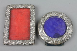 An Edwardian silver circular photograph frame with vinous and floral decoration, Birmingham 1901 2.5" and a rectangular ditto with scroll decoration Birmingham 1907 3" 