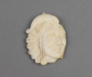 A 19th Century carved ivory native Indian depicting the mask of a chief surmounted by a dolphin 1.75" 