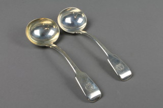 A pair of William IV silver fiddle pattern ladles with engraved crest, London 1834