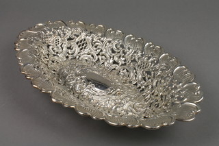 An oval repousse and pierced silver bowl with scroll floral and basket decoration, having a vacant cartouche, indistinct marks, approx 10 ozs, 13" 