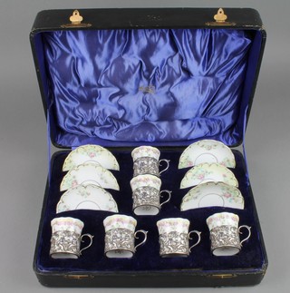 An Edwardian silver mounted 6 piece coffee set, the holders decorated with cherubs at play with vacant cartouche and S shaped handle, Birmingham 1906
