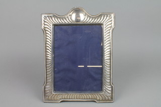 A modern silver photo frame with demi-fluted decoration and vacant cartouche 12" 
