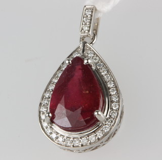 An 18ct white gold diamond set pendant enclosing a pear shaped ruby, approx 5.29ct (treated) 