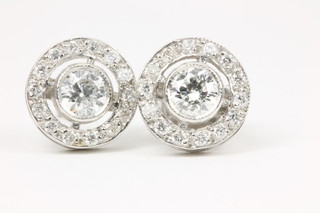 A pair of 18ct white gold diamond earrings with centre briliant cut stones surrounded by small ditto, approx 0.75ct
