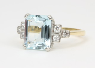 An 18ct yellow gold aquamarine and diamond dress ring, approx 3ct flanked by 3 diamond chips to each shoulder