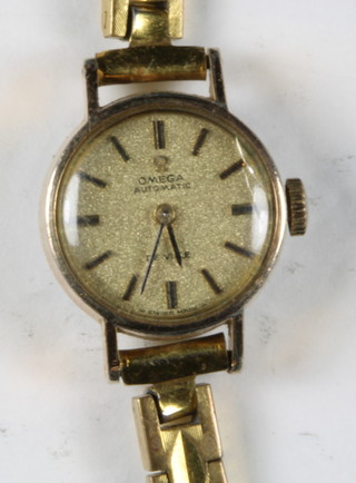 A lady's Omega automatic wristwatch contained in a gold plated case together with a clock in the form of a wrapped present