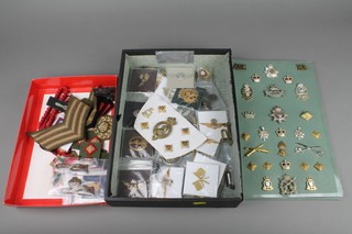 A quantity of metal and cloth cap badges including WWII and later together with cigarette silks of regimental colours and badges 