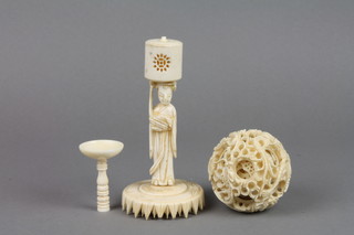 A carved ivory concentric ball on a figural stand with leaf pattern base 10"