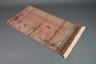 A rose ground Bokhara style Belgian cotton runner 107" x 30"
