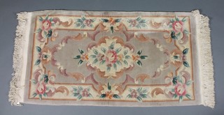 A Chinese peach ground and floral patterned carpet 51 1/2" x 26"