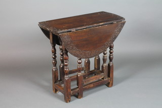 An 18th Century carved oak drop flap gateleg tea table, raised on turned and block supports, drawer missing, 26 1/2" x 29" x 33"