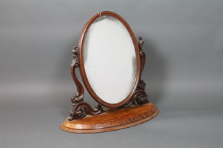 A Victorian oval plate dressing table mirror contained in a swing frame 32"