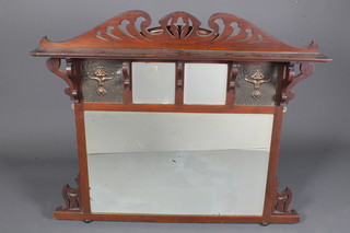 An English Art Nouveau mahogany over mantel mirror having  pierced cornice above 3 bevelled plates, flanked by foliate  embossed copper panels, raised on bun feet 41"h x 48"w