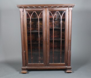A carved mahogany Gothic style 2 door bookcase, on block feet 60" x 47" x 16.5"