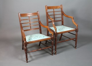 A pair of Victorian aesthetic movement open arm chairs with lattice work backs and upholstered seats, raised on turned supports 