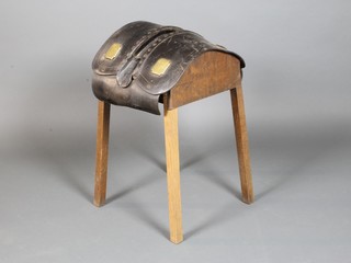 An oak and leather stool formed from a section of heavy horse harness 27"h x 17"w x 15"d