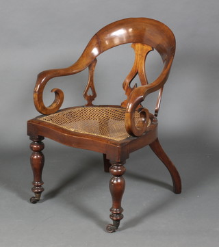 A Victorian mahogany tub back chair with woven rush seat raised on turned legs