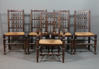 A set of 5 elm spindle back dining chairs with woven rush seats, 1 with arms, raised on turned supports