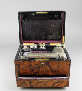 A Victorian figured walnut vanity box with hinged lid, fitted 9 glass bottles, some with plated mounts, the base fitted a secret drawer with hinged lid, retailed by Trussell of 56 East Street, Brighton 8"h x 12"w x 9"d (tongues to lock cut) 